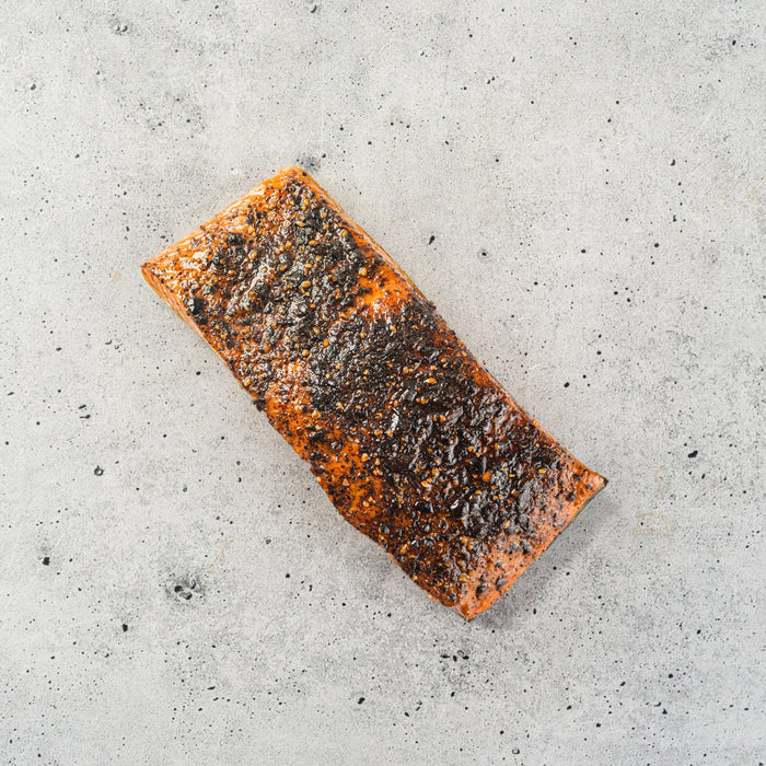 Rectangular piece of seasoned fish on a speckled gray surface