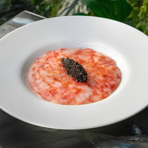 Thinly sliced Gambero Rosso prawn carpaccio from Browne Trading Company, arranged on a plate with garnishes.