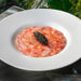 Thinly sliced Gambero Rosso prawn carpaccio from Browne Trading Company, arranged on a plate with garnishes.