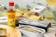Open tin of Olasagasti Basque Anchovies shown with a bottle of hot sauce as a serving suggestion