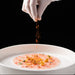 Thinly sliced Gambero Rosso prawn carpaccio from Browne Trading Company, showcasing delicate seafood on a white plate.