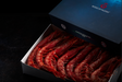 Fresh Gambero Rosso prawns from Browne Trading Company, displayed in a clear container on a bed of ice.