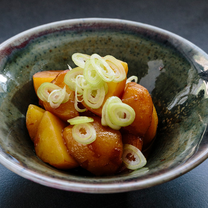 Ito Shoten Tamari bottle with braised potatoes seasoned with soy sauce in a rustic dish.