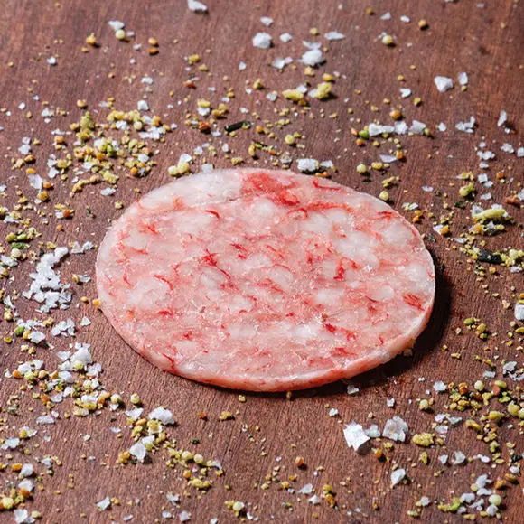Thin slices of Gambero Rosso prawn carpaccio from Browne Trading Company, arranged on a plate with garnish.