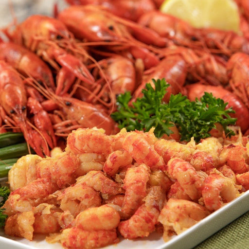 crawfish tails fried and on a white plate with parsley