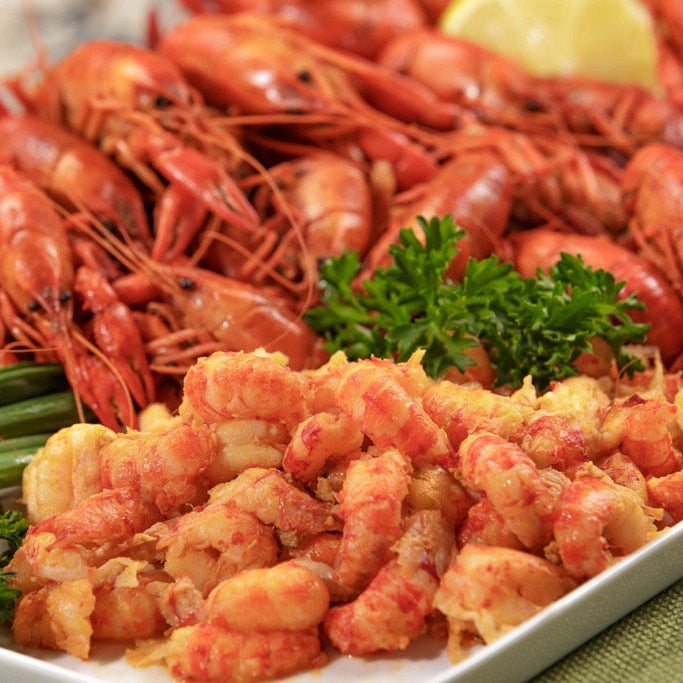 crawfish tails fried and on a white plate with parsley