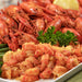 crawfish tails fried and on a white plate with parsley