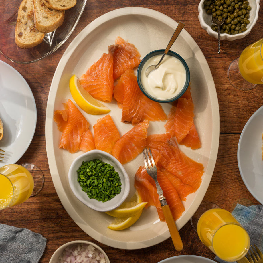 Traditional smoked salmon side by Browne Trading Company, showcasing thin slices of rich, smoked fish on a wooden platter.