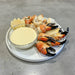 Plated stone crab claws with a side of aioli on a wooden table